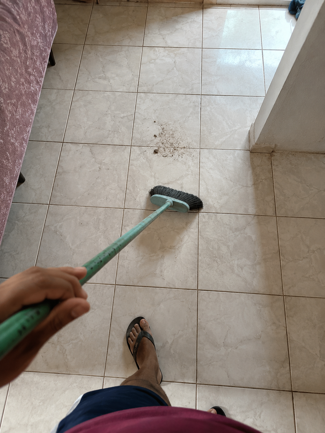 Action view of someone sweeping dust on a Brazilian apartment floor with a broom